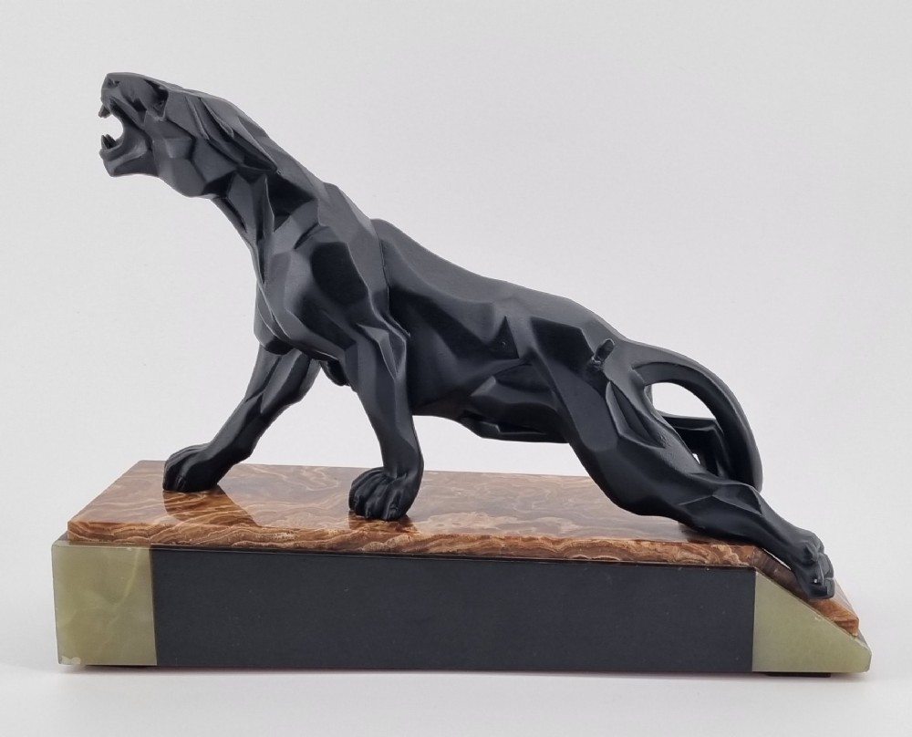 A black Art Deco cubist sculpture of a snarling panther mounted on a layered marble and onyx base.