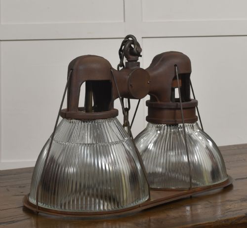 fig 1. A pair of double-dome industrial pendant lights featuring clear ribbed Holophane glass shades set in dark brown metal frames with chain supports.