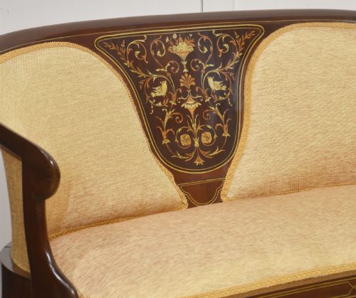fig 1. A matching pair of Edwardian mahogany settees featuring curved backs, floral marquetry central splats, and pale mustard yellow upholstered seats.