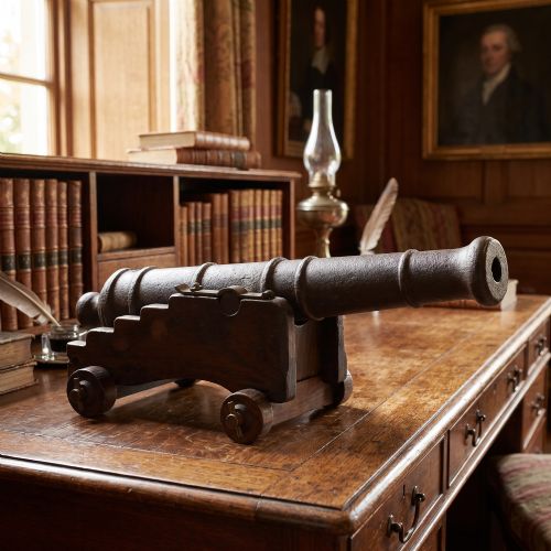 fig 1. A 19th-century cast iron signal cannon mounted on a stepped dark oak carriage with wooden wheels.