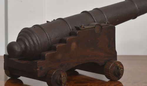 fig 2. A 19th-century cast iron signal cannon mounted on a stepped dark oak carriage with wooden wheels.