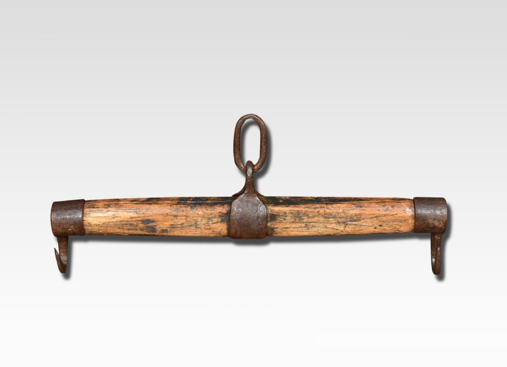 A cylindrical carved oak draught yoke featuring hand-forged wrought iron end hooks and a central iron mounting loop. View II