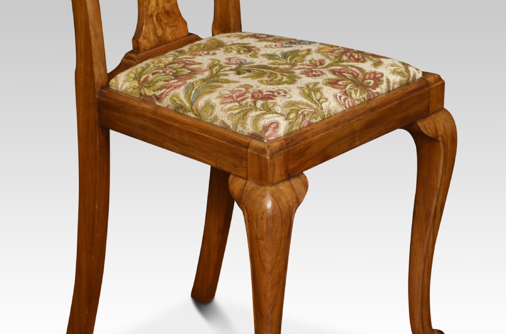 A pair of antique walnut side chairs featuring high backs with central burr walnut splats, floral upholstered seats, and curved cabriole legs. View IV