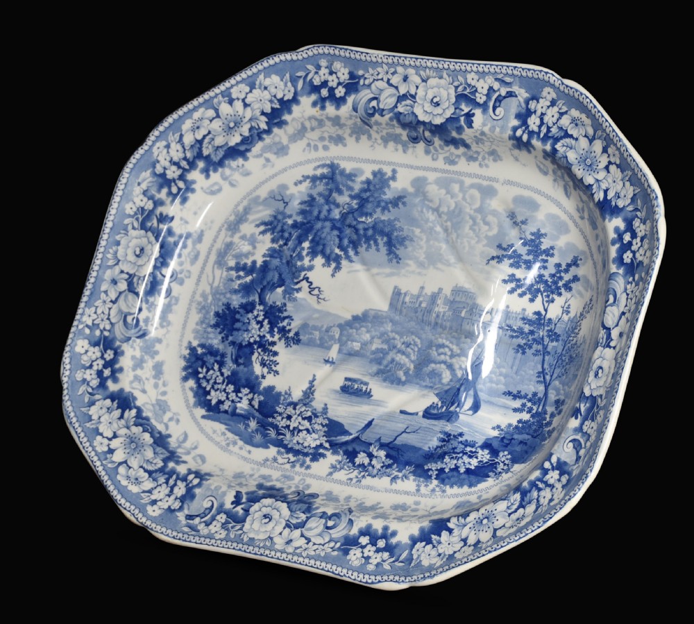 A 19th-century Staffordshire deep rectangular dish featuring cobalt blue transfer-printed floral borders and a central river landscape scene.