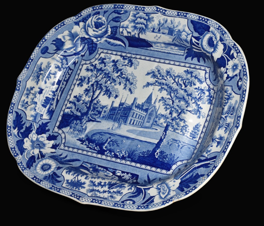 An oval 19th-century Staffordshire ceramic platter featuring a cobalt blue transfer-printed landscape scene with a stately home surrounded by intricate floral borders. View II