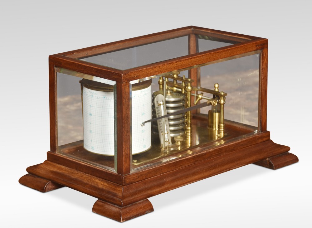 An antique barograph with a brass recording mechanism, clockwork drum, and integrated thermometer inside a glazed walnut case with a stepped base.