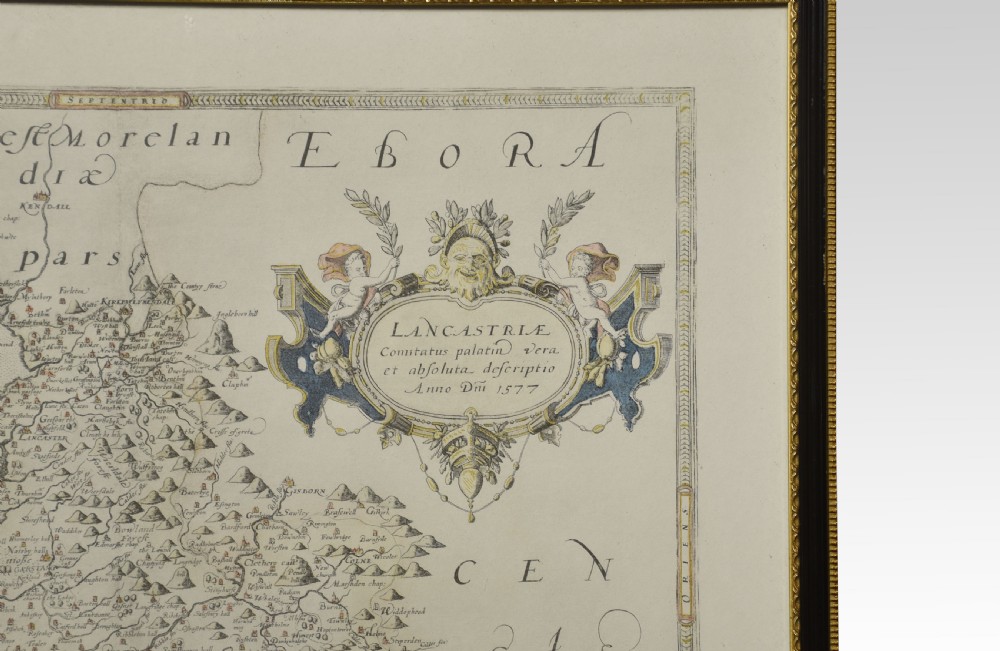 A framed antique map of Lancashire featuring hand-coloured detail, ornate cartouches, and a dark wooden frame with gold inner trim. View V