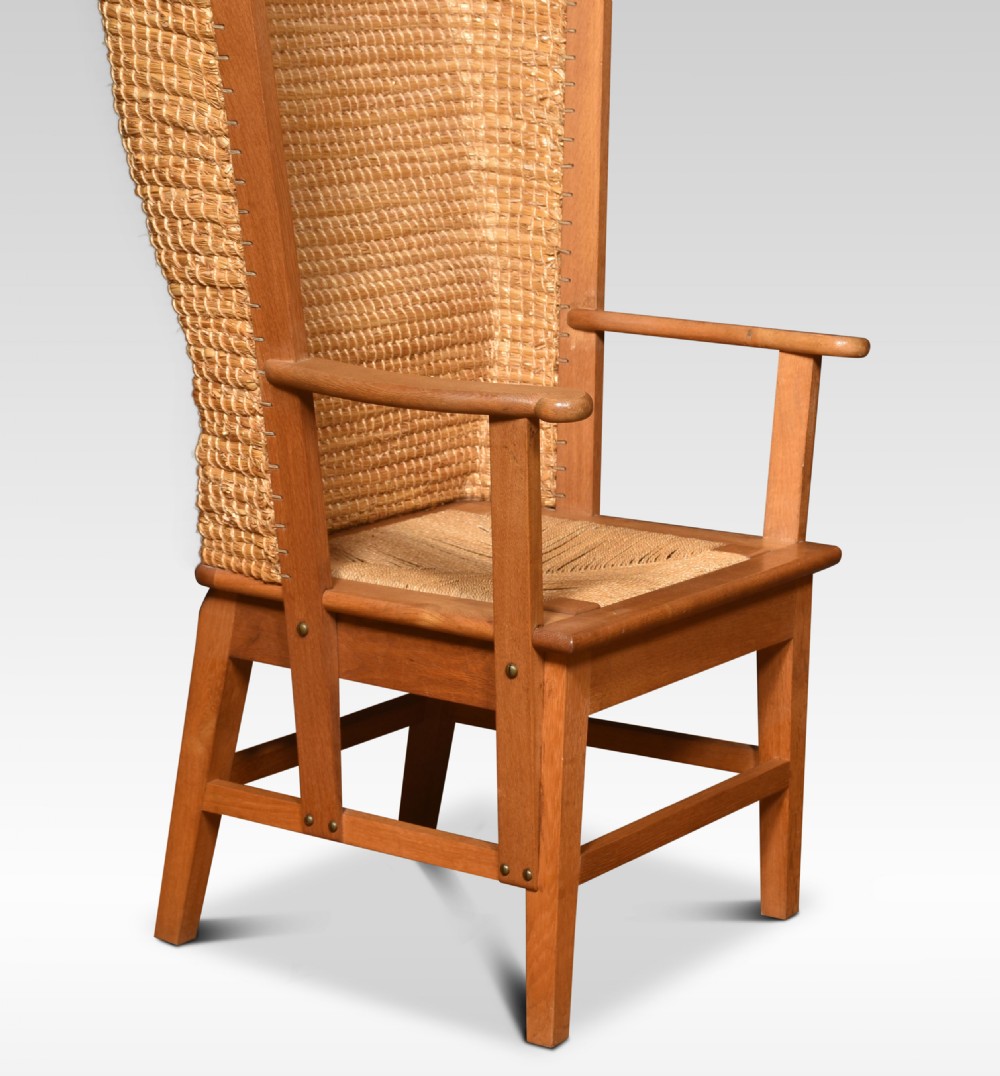 An antique oak-framed Orkney chair featuring a high curved hooded back woven from natural straw and flat timber armrests. View II
