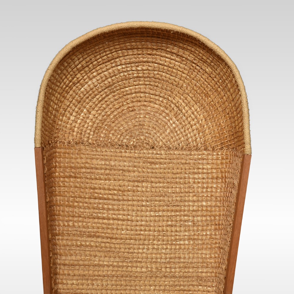 An antique oak-framed Orkney chair featuring a high curved hooded back woven from natural straw and flat timber armrests. View VI