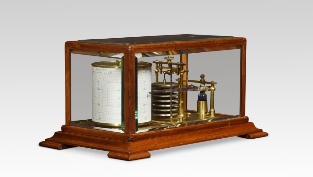 An antique walnut cased barograph featuring bevelled glass panels, a brass clockwork recording drum, and an aneroid mechanism set on a moulded wooden base.