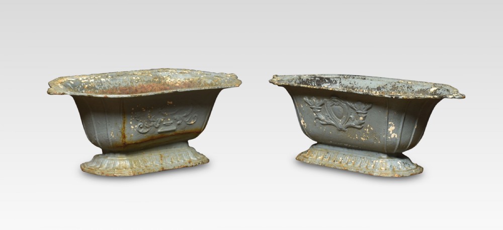 A pair of 19th-century slate grey cast iron trough planters with neoclassical relief decoration and a weathered paint finish.
