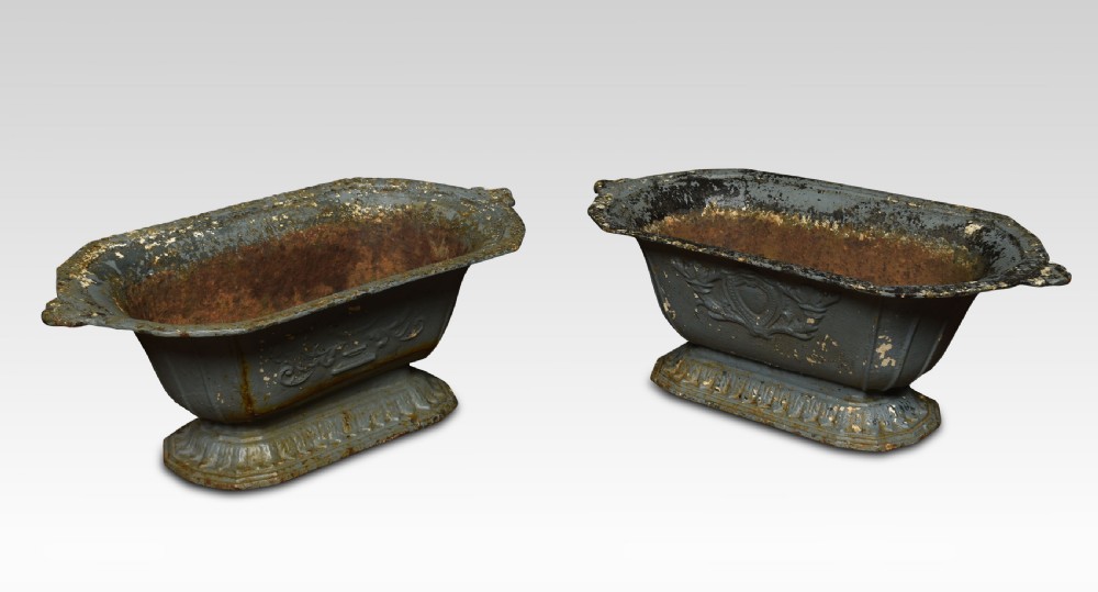 A pair of 19th-century slate grey cast iron trough planters with neoclassical relief decoration and a weathered paint finish. View V