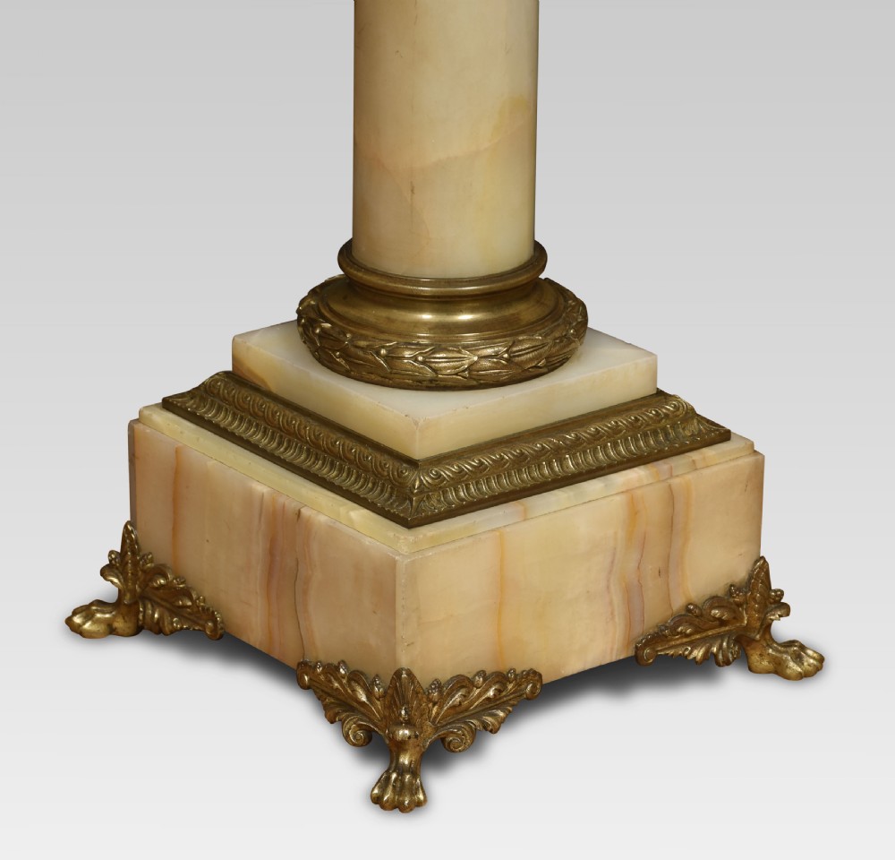 A tall cream onyx column pedestal with a square top, gilt bronze mounts, and decorative feet. View IV