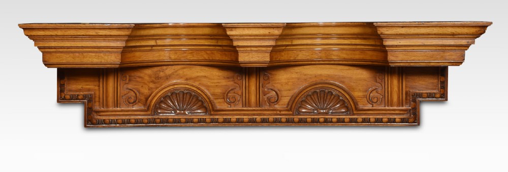 A carved pollard oak overdoor pediment featuring double carved shell motifs, stepped breakfront mouldings, and rich natural wood graining.