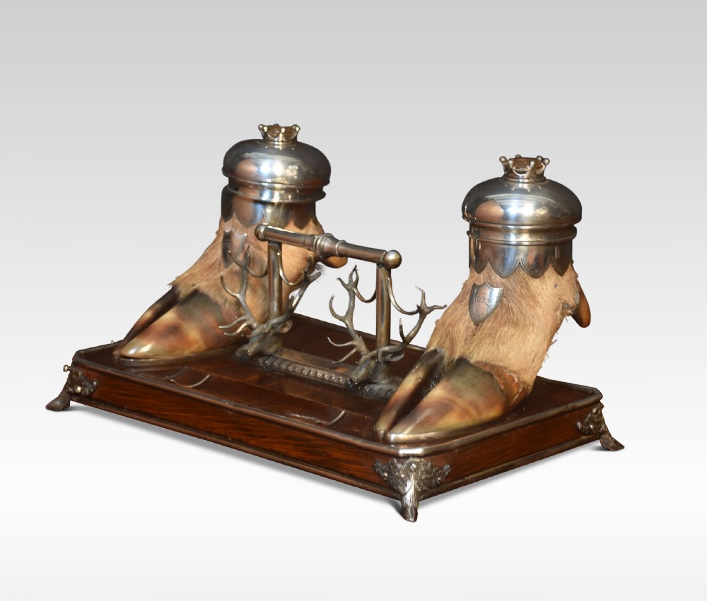 A 19th-century Scottish double inkwell set featuring two silver-capped deer hooves and stag head pen rests mounted on a mahogany base. View II