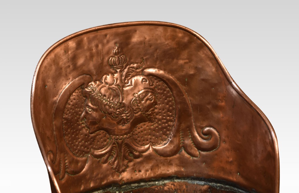 A tall, tapered 19th-century copper log bin featuring a hand-hammered body, raised repousse classical medallion crest, and a scooped upper rim. View III