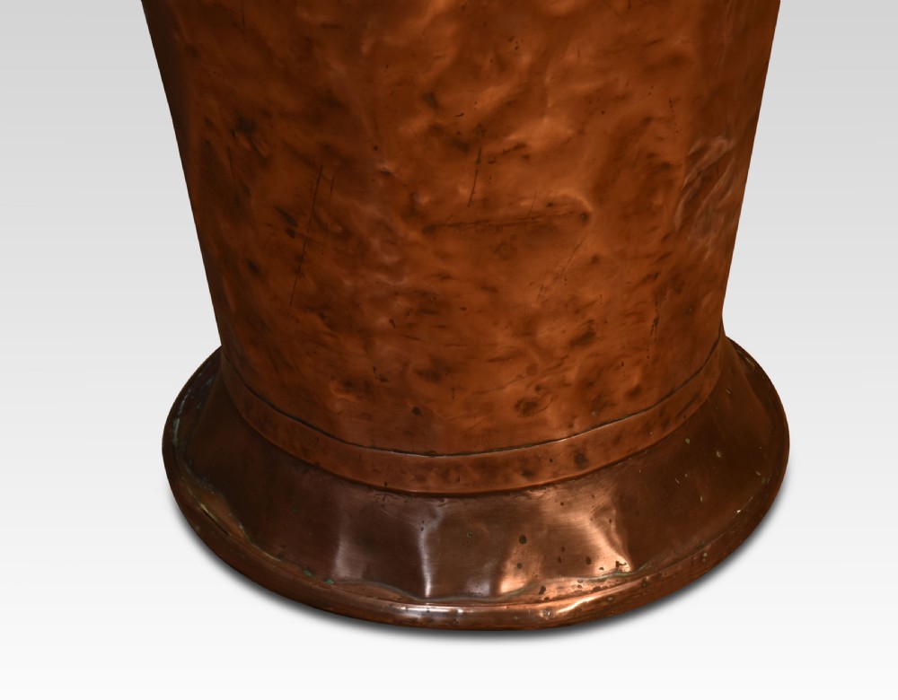 A tall, tapered 19th-century copper log bin featuring a hand-hammered body, raised repousse classical medallion crest, and a scooped upper rim. View IV