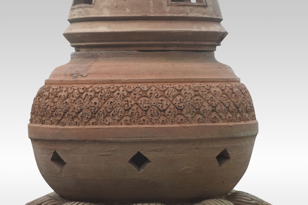 A pair of tall terracotta garden lanterns designed in the shape of stupas with elephant-carved bases, tiered lotus motifs, and pointed finials. View VI