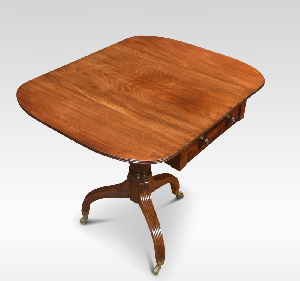 A Regency mahogany Pembroke end table featuring two drop leaves, a single frieze drawer, a reeded pedestal stem, and tripod legs with brass castors. View IV