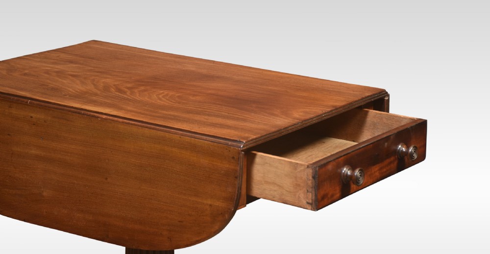 A Regency mahogany Pembroke end table featuring two drop leaves, a single frieze drawer, a reeded pedestal stem, and tripod legs with brass castors. View V