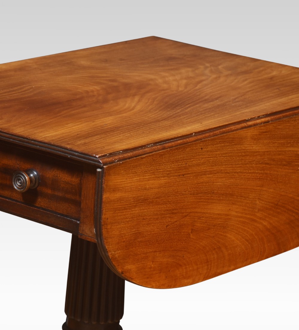 A Regency mahogany Pembroke end table featuring two drop leaves, a single frieze drawer, a reeded pedestal stem, and tripod legs with brass castors. View VI