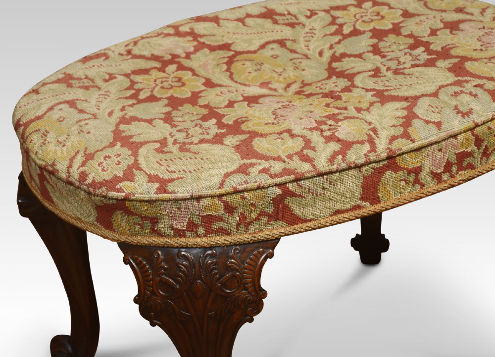 An oval George II style stool featuring patterned tapestry upholstery, carved mahogany cabriole legs, and scroll feet. View VI