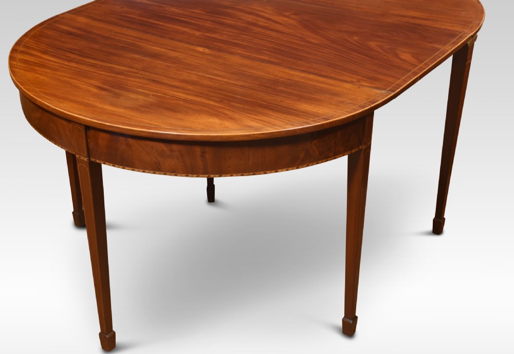 A Georgian flame mahogany D-end dining table featuring tapered square legs with stringing inlay and a polished wood top. View II
