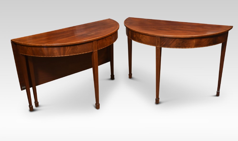 A Georgian flame mahogany D-end dining table featuring tapered square legs with stringing inlay and a polished wood top. View IV