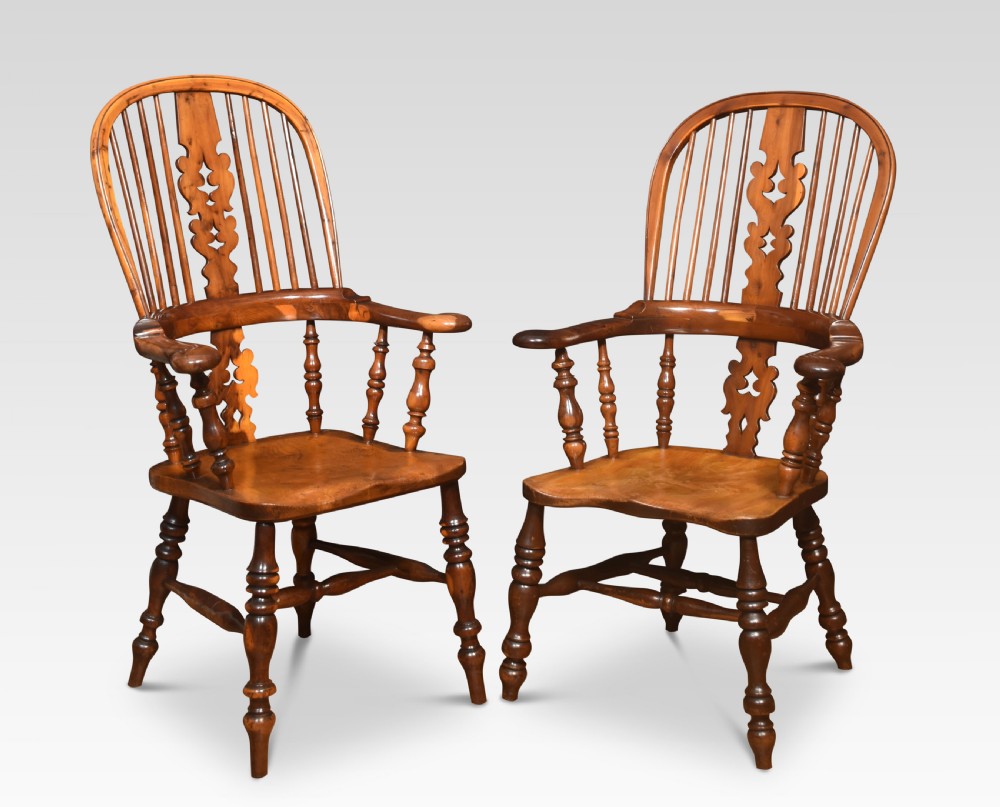 A matched set of six 19th century yew wood Windsor armchairs with pierced central splats, spindled hoop backs, and turned legs. View II