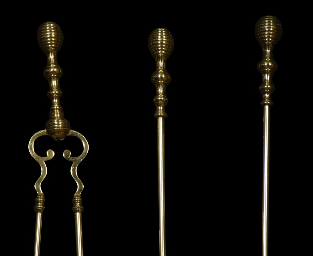 A three-piece polished brass fire tool set including tongs, a pierced shovel, and a steel-tipped poker, featuring ribbed beehive finials. View II