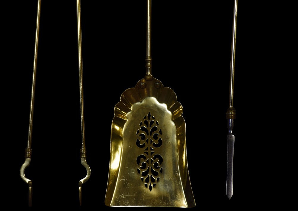 A three-piece polished brass fire tool set including tongs, a pierced shovel, and a steel-tipped poker, featuring ribbed beehive finials. View VI