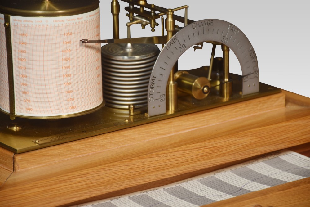 An antique oak and glass cased barograph by Negretti and Zambra featuring an internal clockwork drum, aneroid capsule stack, curved silvered scale, and base drawer. View IV
