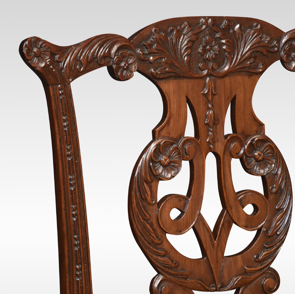 A pair of Chippendale Revival mahogany side chairs with carved pierced back splats, cabriole legs terminating in claw and ball feet, and light brown upholstered seats. View V