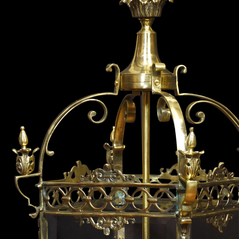 A pair of large brass hall lanterns with decorative scrollwork, glass side panels, finials, and internal four-bulb fittings. View VII