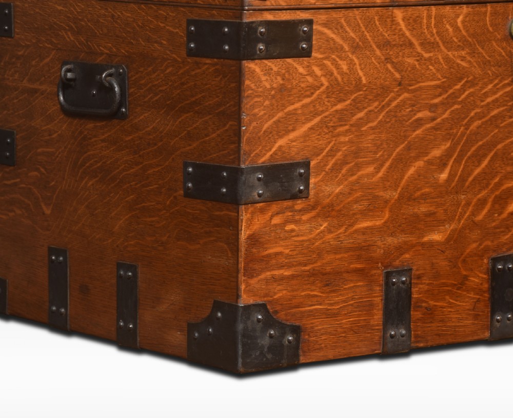 A 19th-century oak silver chest reinforced with black iron corner brackets and strapwork, shown with its lid open to display a blue padded fabric interior lining. View VI