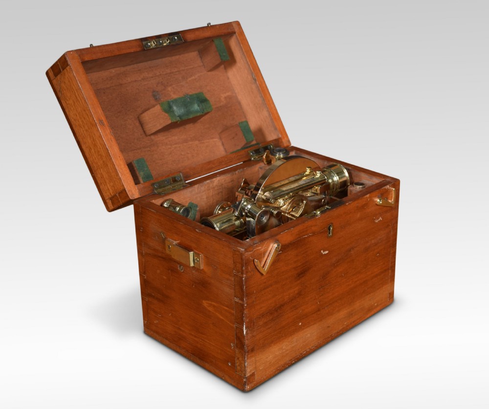 An antique brass theodolite optical instrument with calibrated dials mounted on a tall three-legged wooden tripod stand. View III