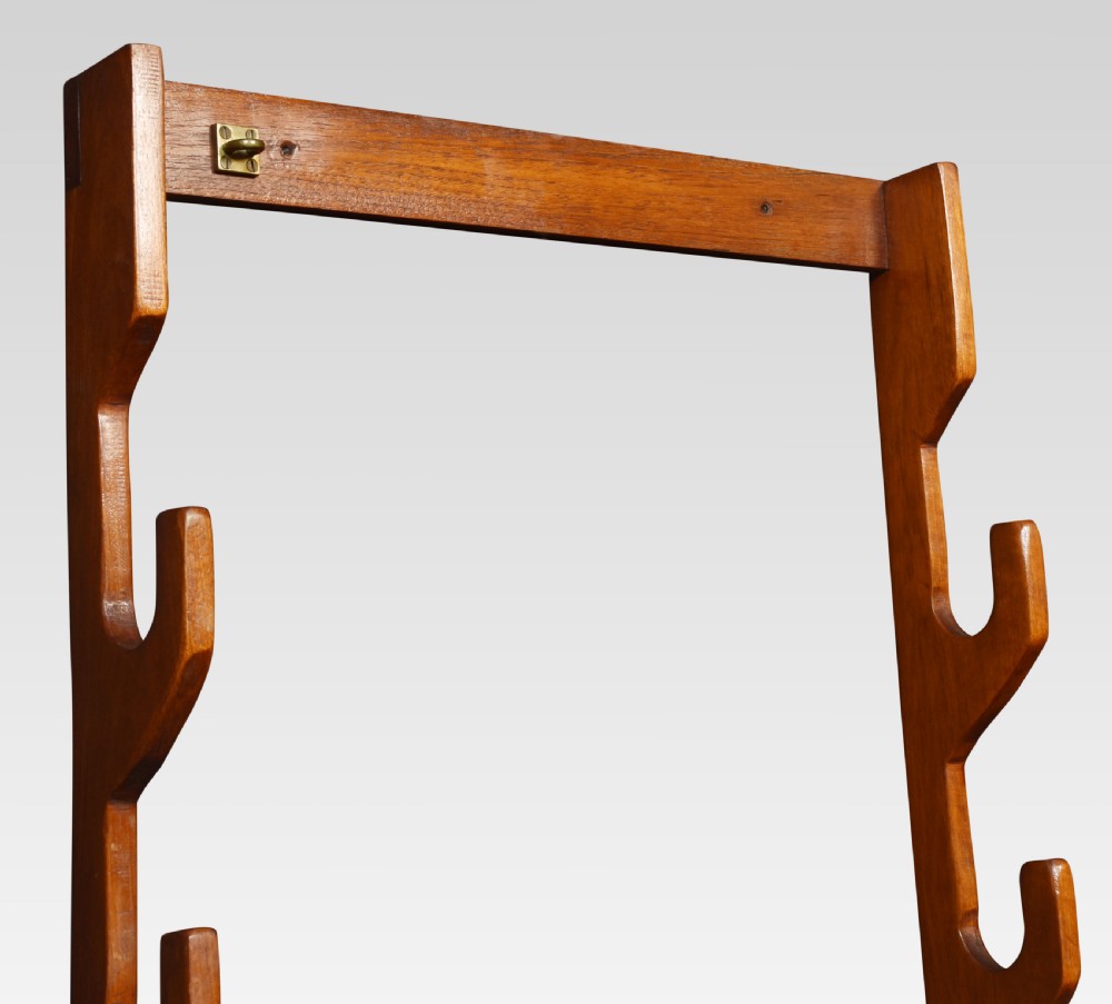 A rectangular wall-mounted walnut rack with four shaped side notches and brass fixing plates at the top and bottom. View II