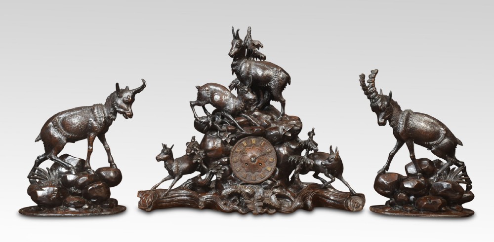 A nineteenth-century Black Forest carved wood mantel clock garniture set featuring sculpted alpine chamois figures atop rocky outcrops. View II