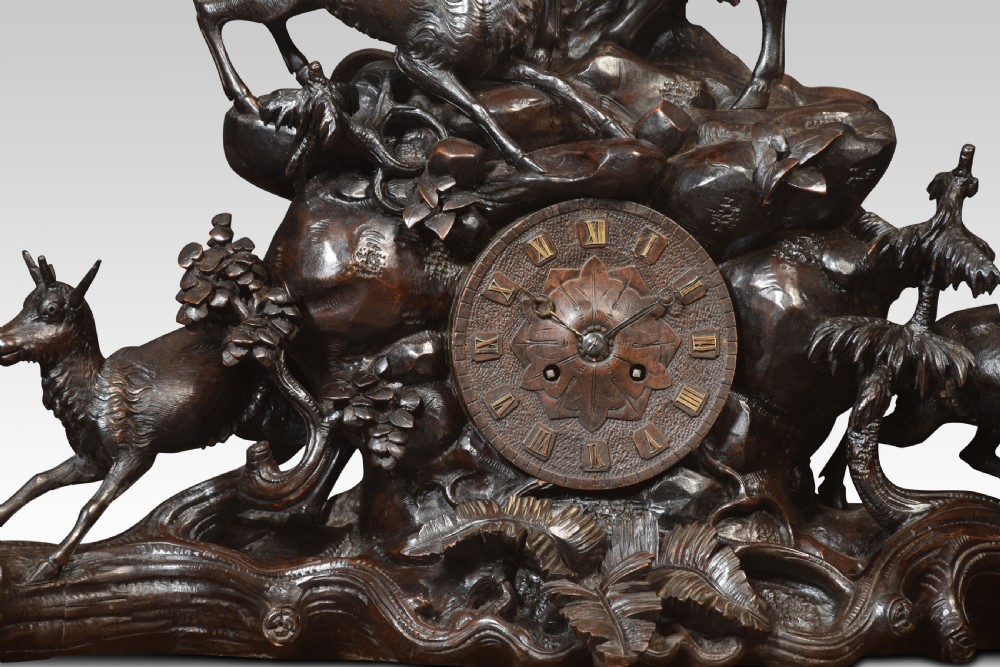 A nineteenth-century Black Forest carved wood mantel clock garniture set featuring sculpted alpine chamois figures atop rocky outcrops. View III
