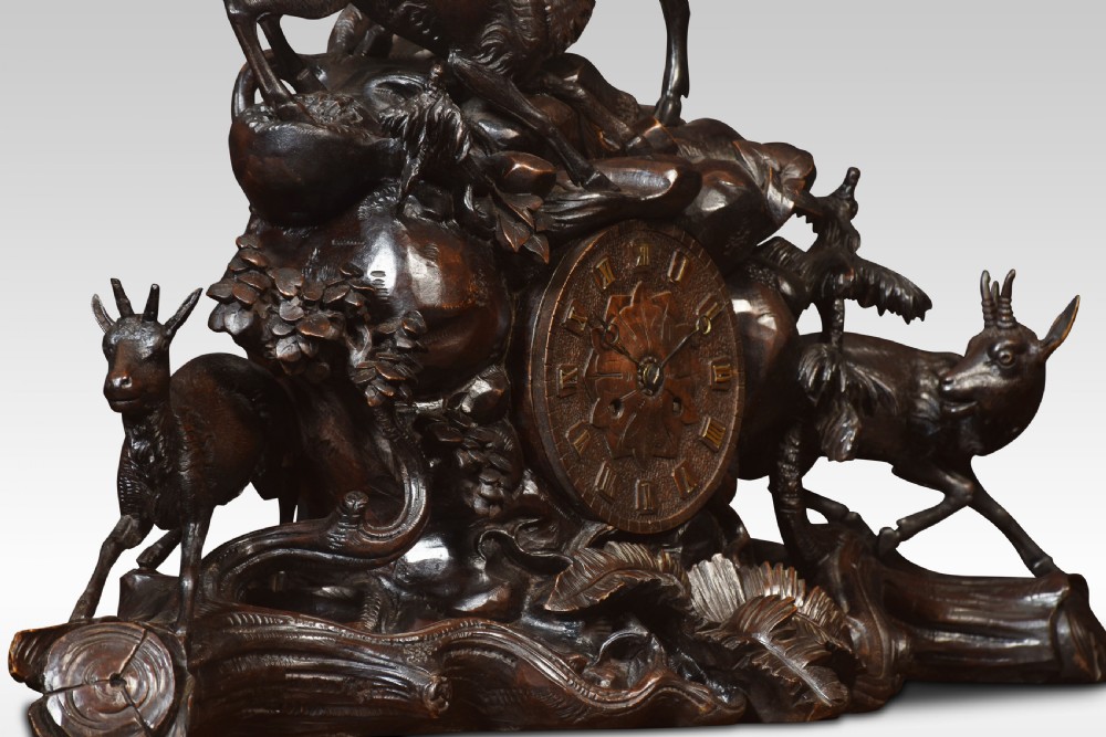 A nineteenth-century Black Forest carved wood mantel clock garniture set featuring sculpted alpine chamois figures atop rocky outcrops. View V