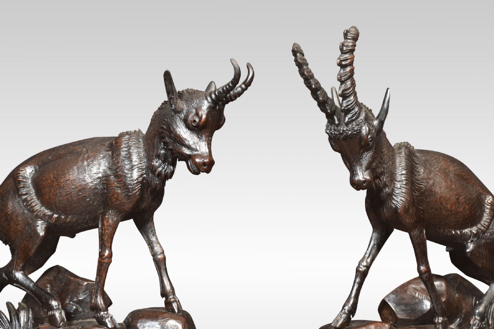 A nineteenth-century Black Forest carved wood mantel clock garniture set featuring sculpted alpine chamois figures atop rocky outcrops. View XIV