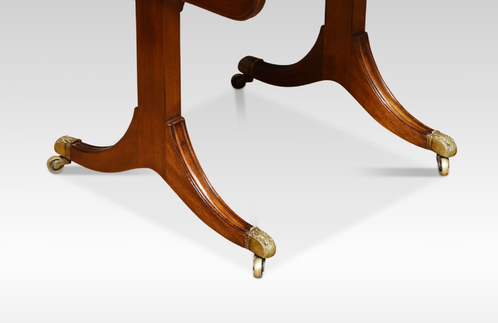 A Regency mahogany drop-leaf sofa table featuring two front drawers with brass knobs, mounted on splayed sabre legs with brass paw castors. View III
