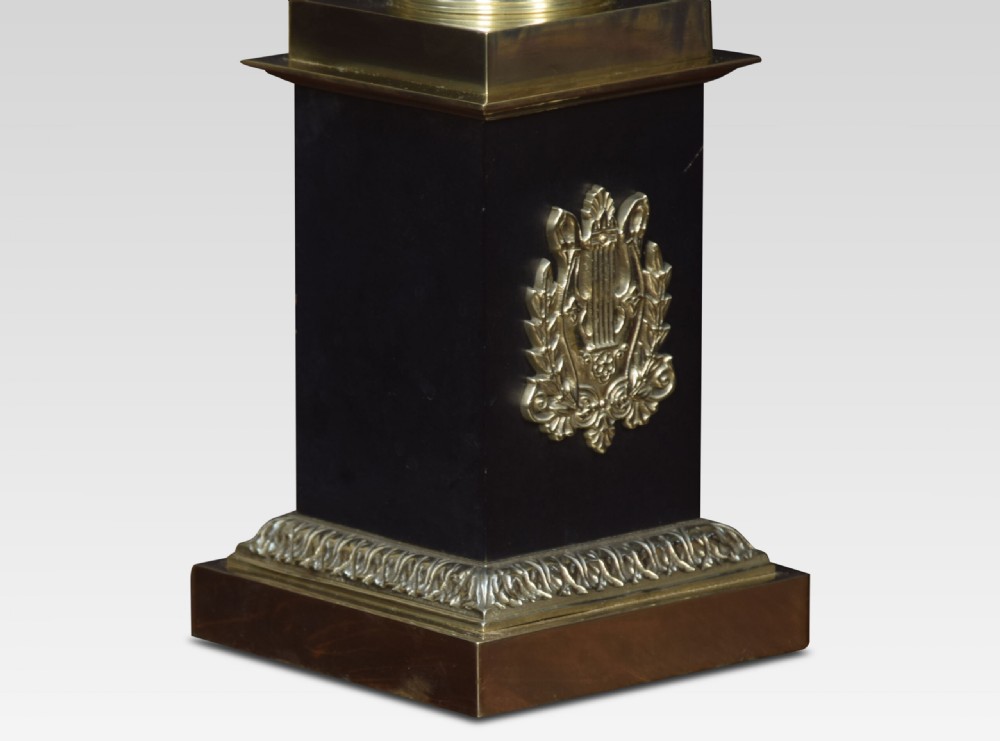 A Neoclassical style brass urn table lamp with twin handles, mounted on a dark square plinth and topped with a cream pleated fabric shade. View III