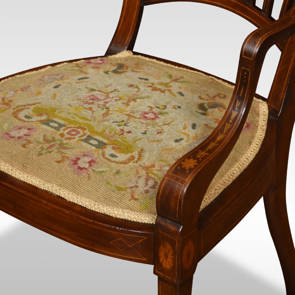 An antique Edwardian inlaid mahogany open armchair with an embroidered floral needlepoint seat, shaped arms, and tapered legs. View IV