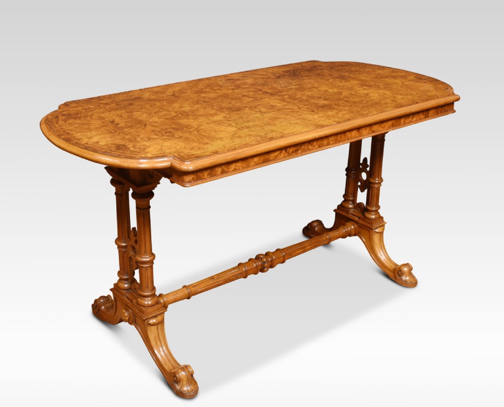 An antique Victorian burr walnut centre table featuring a figured inlaid top, twin turned column supports, a turned stretcher, and carved scrolled feet. View II