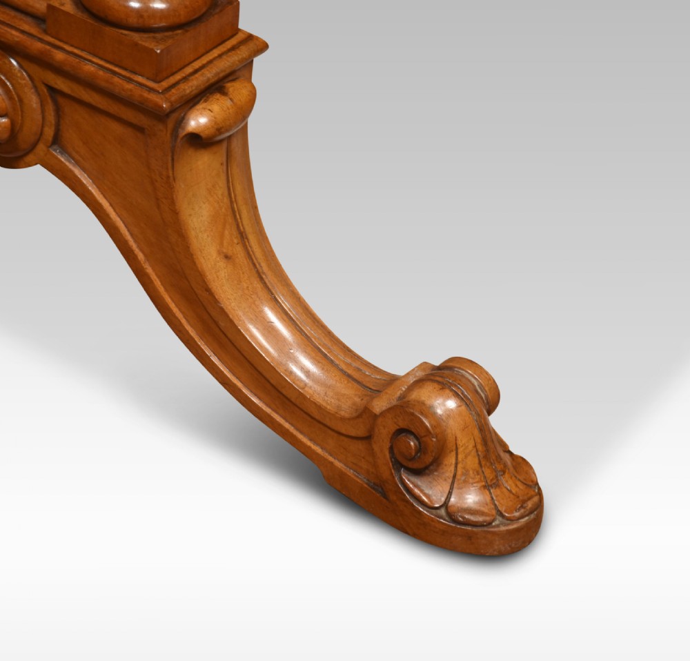 An antique Victorian burr walnut centre table featuring a figured inlaid top, twin turned column supports, a turned stretcher, and carved scrolled feet. View V
