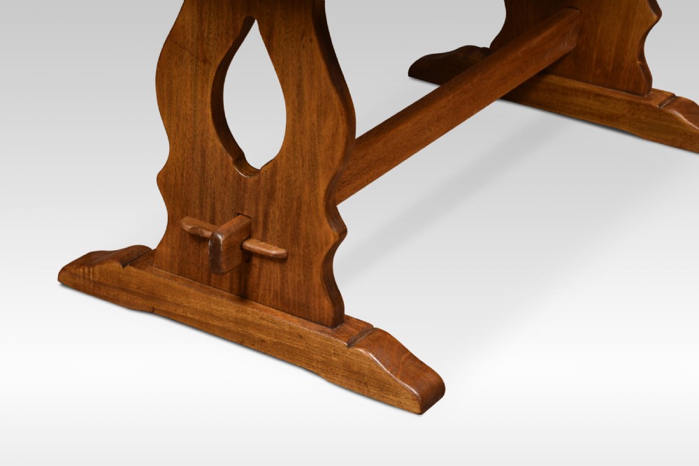 A rectangular oak refectory table featuring a thick plank top and trestle base joined by a central stretcher. View V