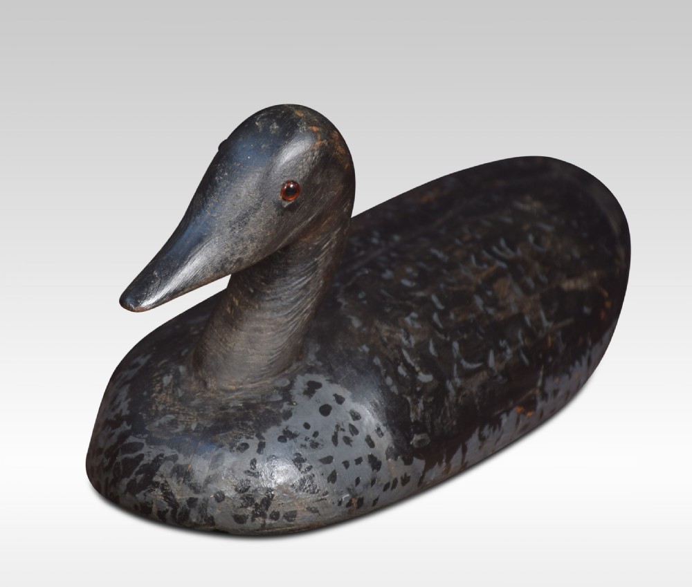 A set of three hand-carved wooden bird decoys painted in dark grey and black with mottled detailing and inset eyes. View III