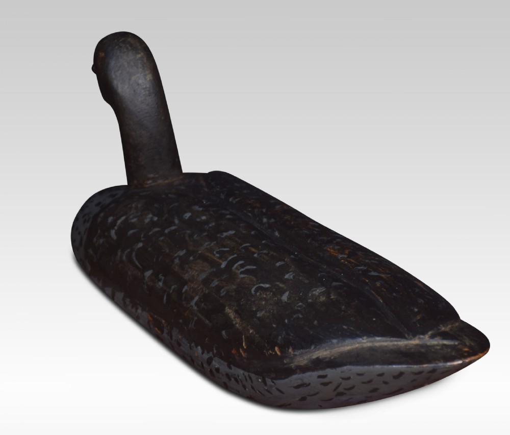 A set of three hand-carved wooden bird decoys painted in dark grey and black with mottled detailing and inset eyes. View IV