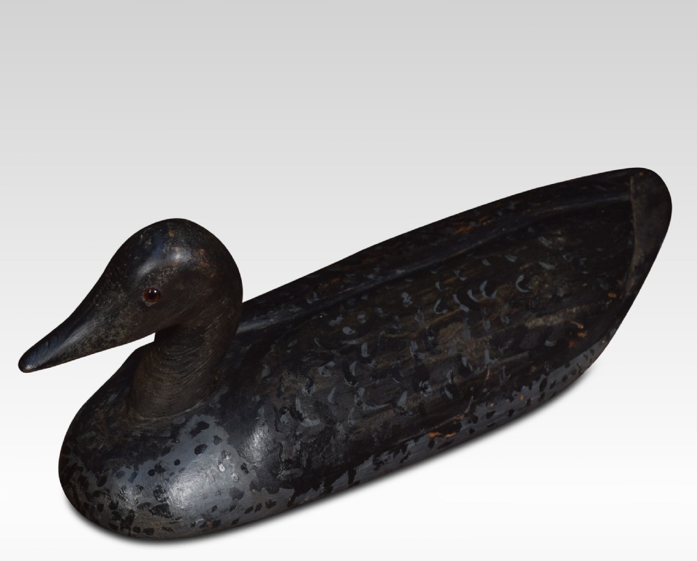 A set of three hand-carved wooden bird decoys painted in dark grey and black with mottled detailing and inset eyes. View V